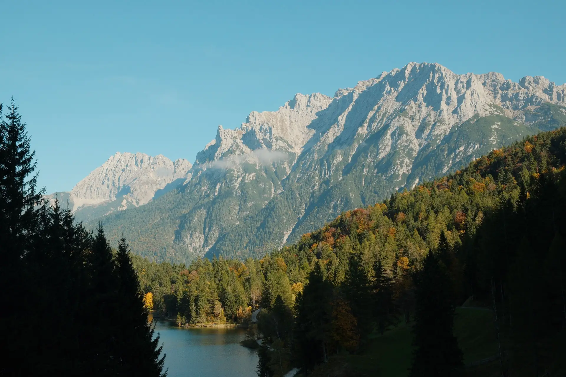 Atemberaubende bayerische Alpenlandschaft mit herbstlichem Wald bei Mittenwald